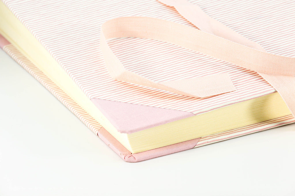 Legaccio di chiusura in cotone sulla copertina in carta a righine rosa